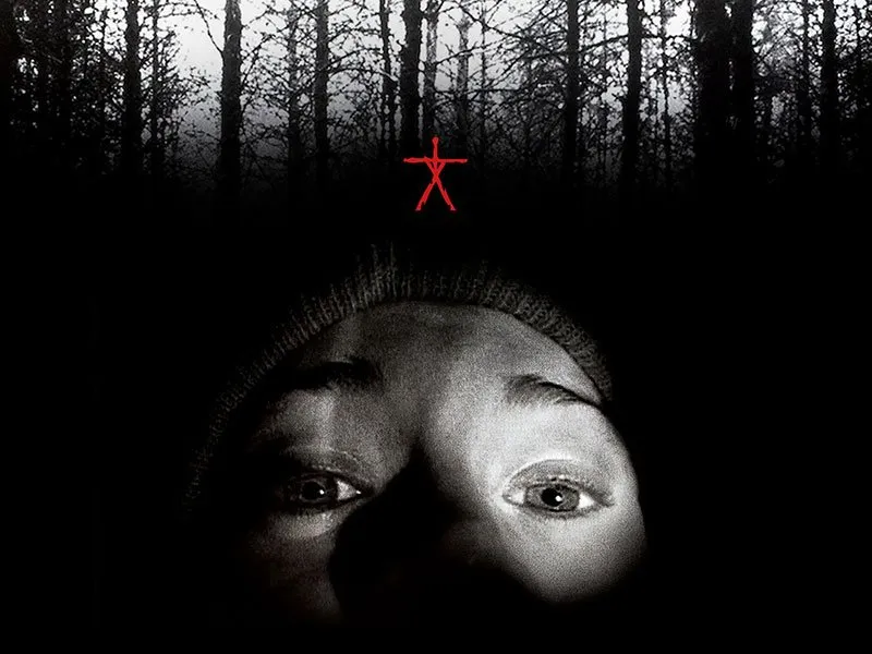 A close-up of a persons frightened face at the bottom, with wide eyes staring upward, and a red stick figure symbol above them against a dark, shadowy forest background.